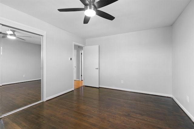 unfurnished bedroom featuring a closet, baseboards, wood finished floors, and a ceiling fan