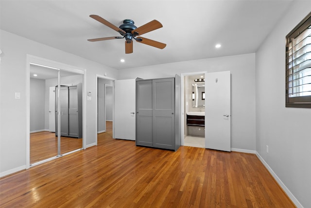 unfurnished bedroom featuring recessed lighting, baseboards, wood finished floors, and ensuite bathroom