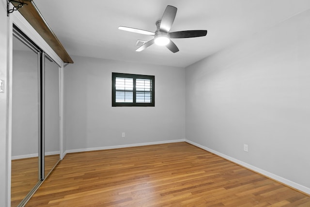 unfurnished bedroom featuring baseboards, light wood-type flooring, and a closet