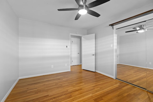 unfurnished bedroom with a closet, a ceiling fan, baseboards, and light wood finished floors