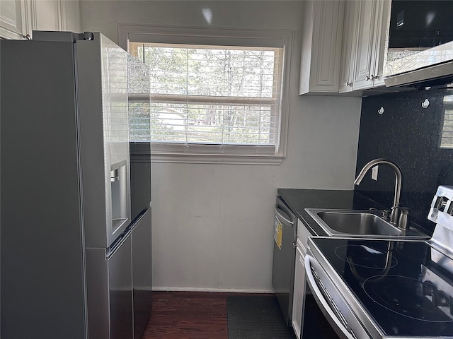 kitchen featuring a sink, white cabinets, dark wood finished floors, and stainless steel appliances