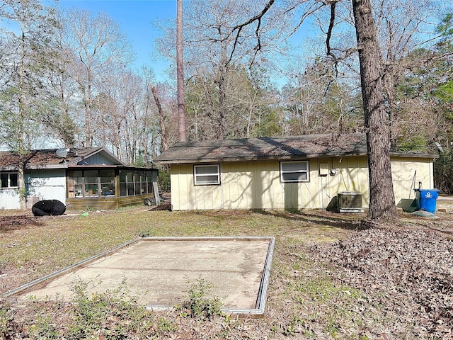 view of home's exterior with cooling unit, a yard, and a sunroom