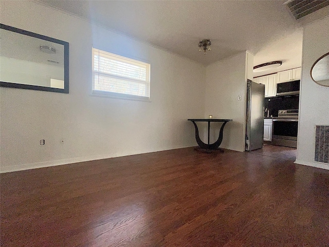 unfurnished room featuring dark wood-style floors and visible vents