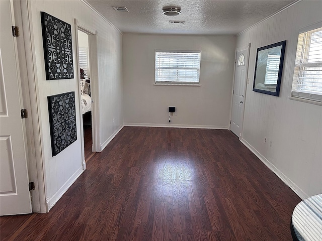 spare room featuring visible vents, ornamental molding, a textured ceiling, and wood finished floors