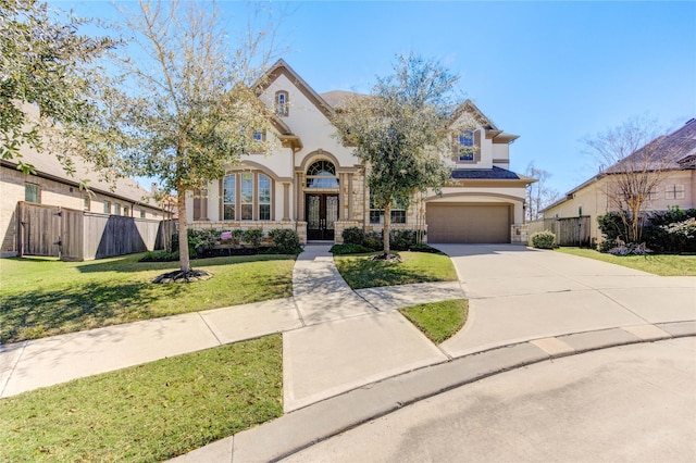 view of front of house featuring a front yard, fence, an attached garage, stucco siding, and french doors