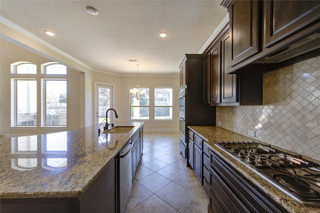 kitchen with light stone countertops, a sink, dark brown cabinets, appliances with stainless steel finishes, and crown molding