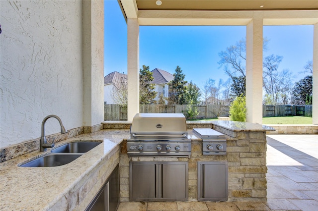 view of patio / terrace with a sink, area for grilling, and a fenced backyard