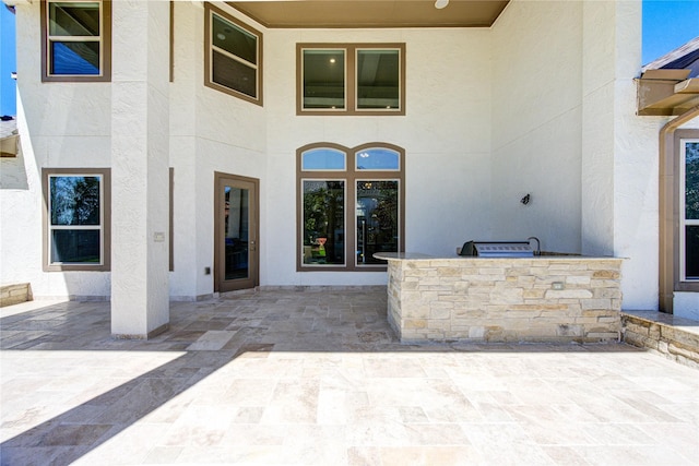 doorway to property featuring stucco siding and a patio area