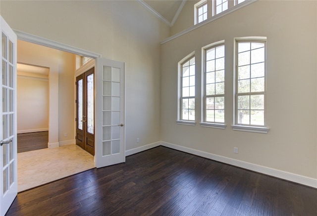 foyer entrance with ornamental molding, french doors, baseboards, and dark wood-style flooring