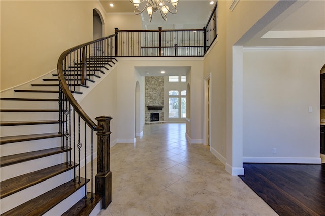 foyer entrance featuring arched walkways, baseboards, an inviting chandelier, and ornamental molding