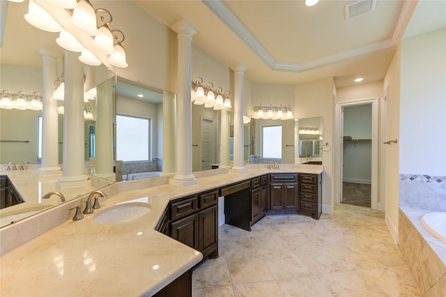 bathroom with visible vents, decorative columns, ornamental molding, a raised ceiling, and a bath