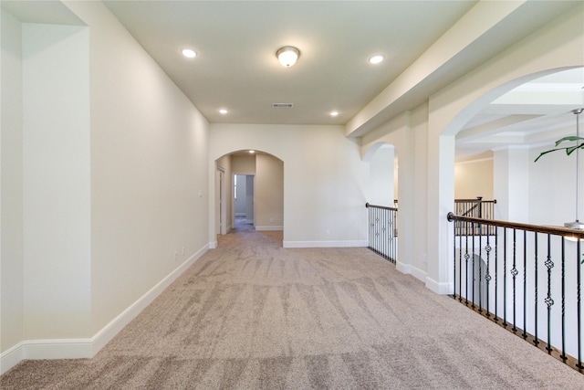 corridor with visible vents, baseboards, recessed lighting, arched walkways, and carpet flooring