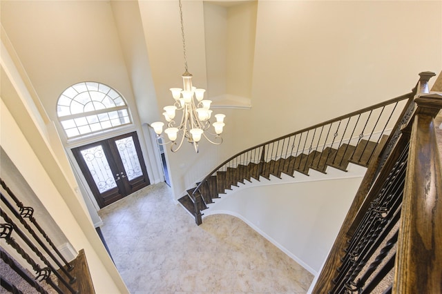 entrance foyer featuring a notable chandelier, french doors, stairs, and a high ceiling