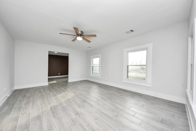 unfurnished room featuring visible vents, baseboards, light wood-style floors, and ceiling fan