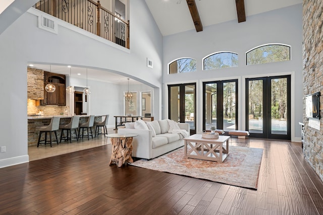 living area featuring visible vents, a healthy amount of sunlight, and wood finished floors