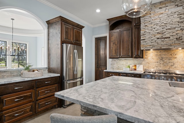 kitchen with dark brown cabinetry, appliances with stainless steel finishes, crown molding, decorative backsplash, and light stone countertops