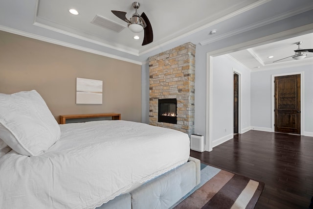 bedroom featuring visible vents, baseboards, ornamental molding, a fireplace, and wood finished floors