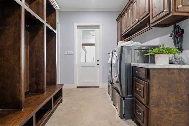 clothes washing area with baseboards, light colored carpet, ornamental molding, cabinet space, and separate washer and dryer