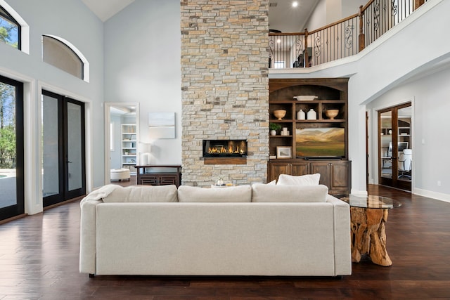 living room with a fireplace, high vaulted ceiling, dark wood-type flooring, and baseboards