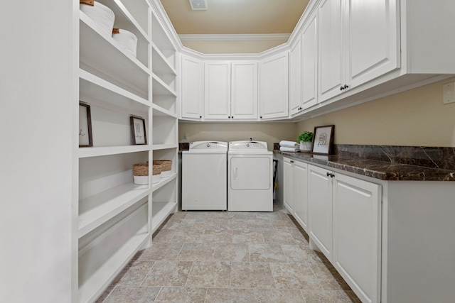 laundry area with cabinet space, separate washer and dryer, and stone finish flooring