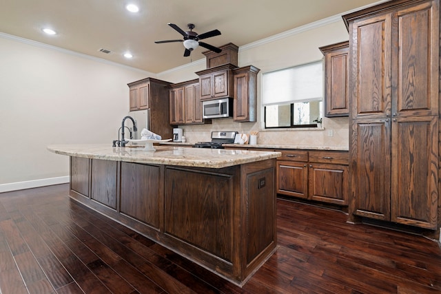 kitchen with visible vents, stainless steel appliances, dark wood-type flooring, and a kitchen island with sink