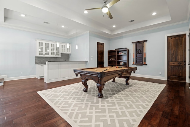 recreation room with visible vents, ceiling fan, a tray ceiling, and dark wood-style flooring