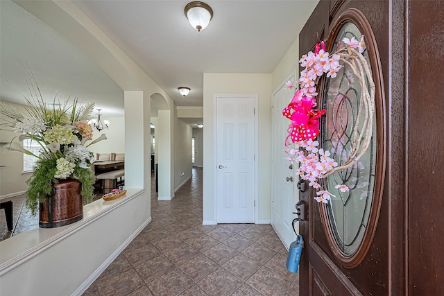 entryway featuring arched walkways and baseboards