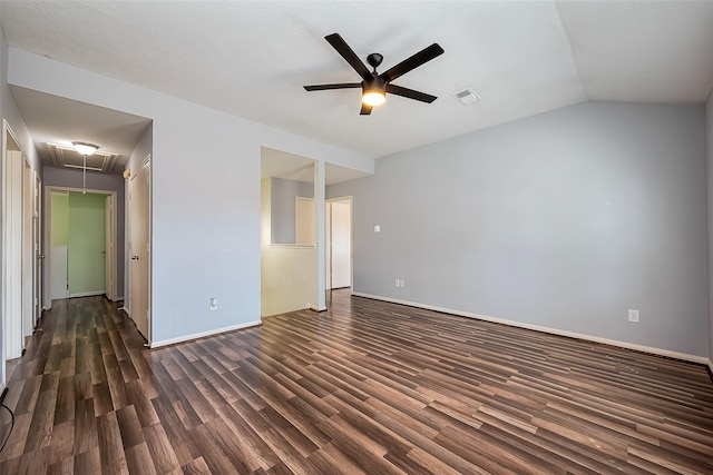 unfurnished bedroom with baseboards, visible vents, dark wood finished floors, attic access, and a walk in closet