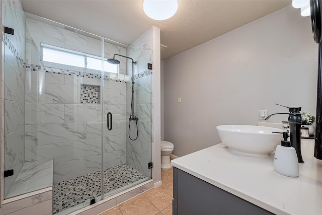 bathroom featuring tile patterned floors, a stall shower, toilet, and vanity