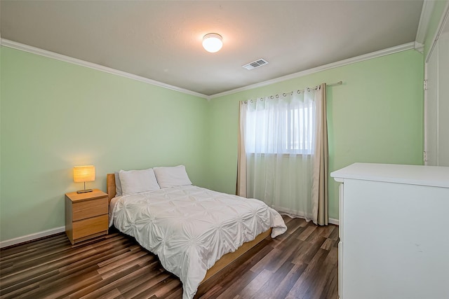 bedroom featuring dark wood finished floors, visible vents, baseboards, and ornamental molding