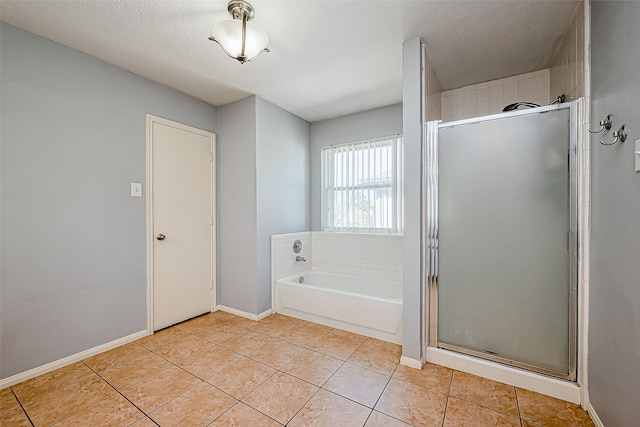 full bath featuring tile patterned floors, a garden tub, baseboards, and a stall shower