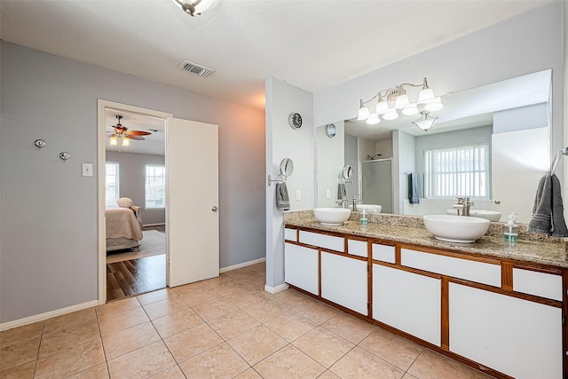 ensuite bathroom featuring visible vents, a shower stall, connected bathroom, tile patterned floors, and a sink