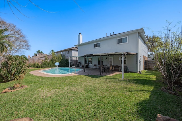 back of house featuring a yard, a patio, and a fenced backyard