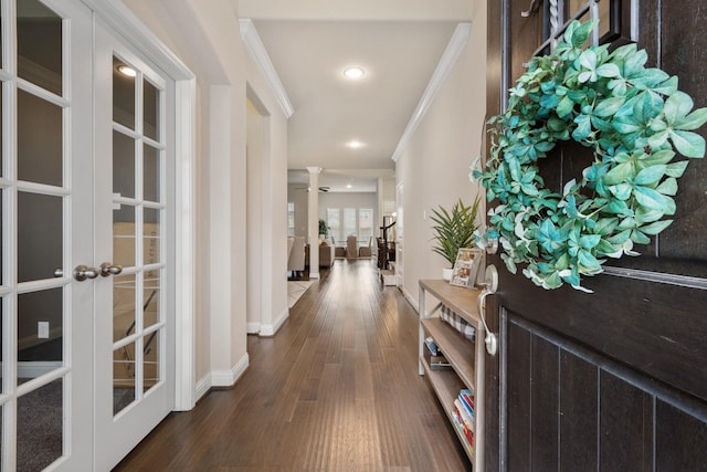 hall featuring french doors, baseboards, dark wood-type flooring, and ornamental molding