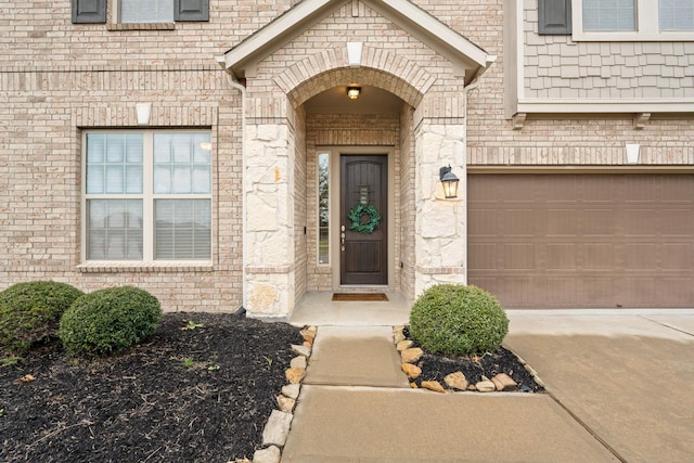 property entrance with stone siding, brick siding, and driveway