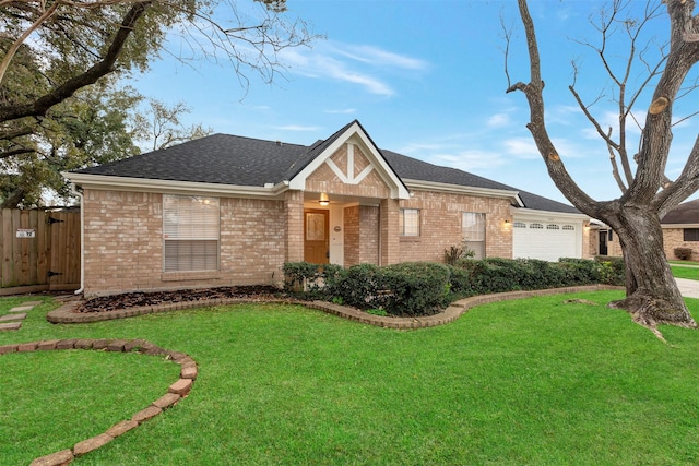 view of front of property featuring fence, a front yard, a shingled roof, a garage, and brick siding