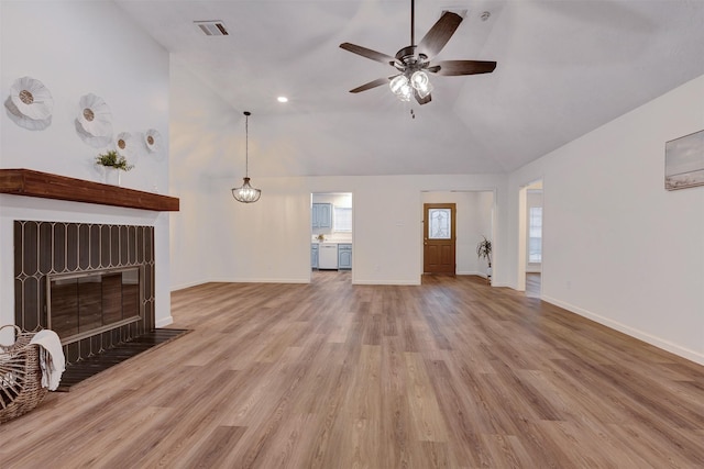 unfurnished living room with a fireplace with flush hearth, wood finished floors, visible vents, and ceiling fan