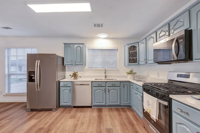 kitchen with gray cabinetry, visible vents, appliances with stainless steel finishes, and a sink