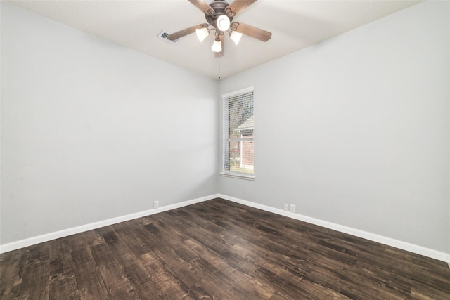 empty room with dark wood finished floors, visible vents, a ceiling fan, and baseboards