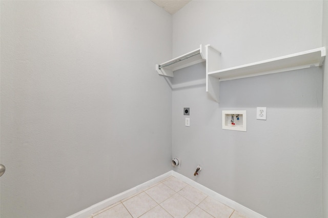 clothes washing area featuring electric dryer hookup, washer hookup, hookup for a gas dryer, light tile patterned floors, and laundry area