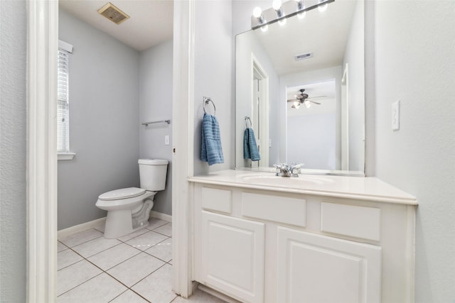 bathroom featuring vanity, baseboards, visible vents, tile patterned floors, and toilet