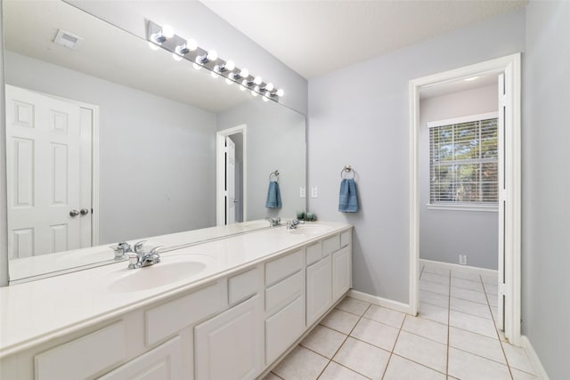 full bathroom with tile patterned floors, double vanity, baseboards, and a sink