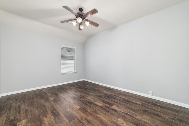 empty room featuring lofted ceiling, dark wood-style floors, baseboards, and ceiling fan