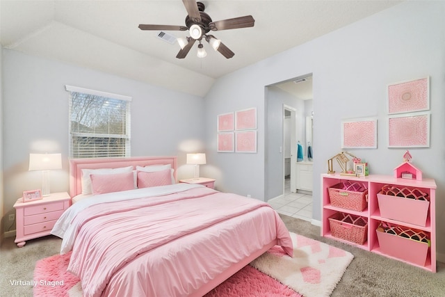 bedroom featuring visible vents, lofted ceiling, ensuite bathroom, and carpet flooring