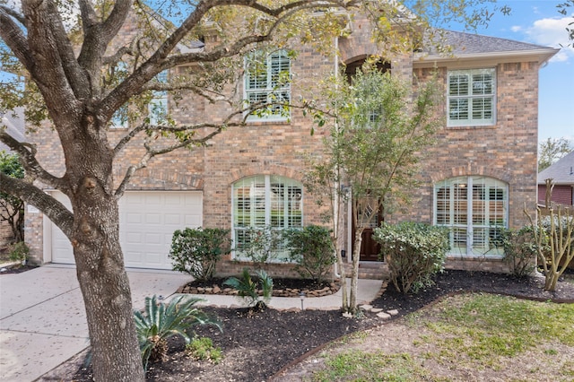 view of front of home featuring brick siding, concrete driveway, and roof with shingles