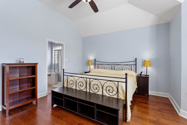 bedroom featuring vaulted ceiling, wood finished floors, baseboards, and connected bathroom