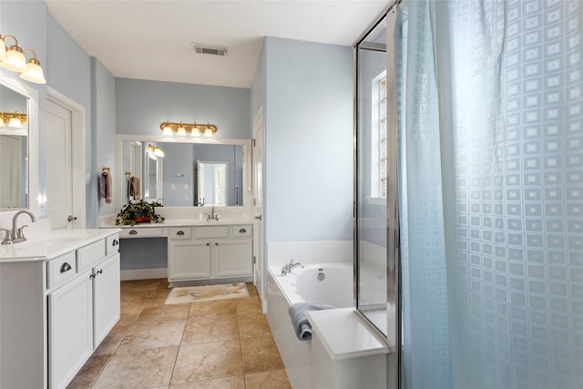 bathroom featuring visible vents, two vanities, a tile shower, a sink, and a garden tub