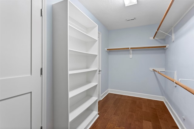 spacious closet featuring dark wood-style floors and visible vents