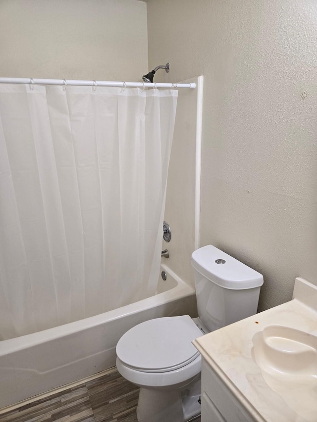 bathroom featuring vanity, toilet, wood finished floors, and shower / bath combo