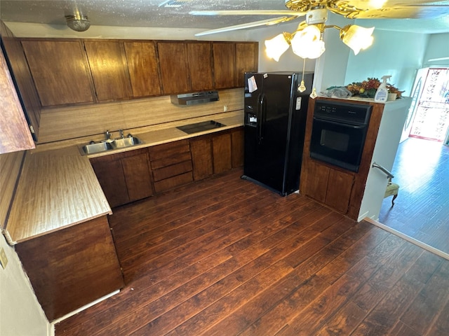 kitchen with dark wood finished floors, light countertops, black appliances, a ceiling fan, and a sink